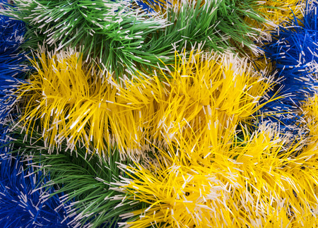 Intertwined Christmas tinsel yellow, green and blueの写真素材