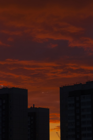 silhouettes of buildings against the background of the red sky at sunset before a thunder-stormの写真素材