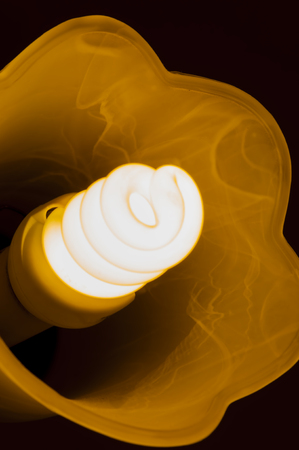 the burning lamp in a plafond against a dark background