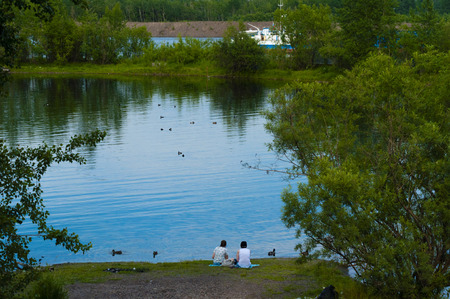 the small beach on the bank of the lake, two human figuresの写真素材
