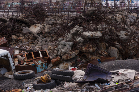garbage dump of concrete and metal waste, old car tires, and car partsの写真素材