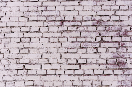 Wall of dark red brick in places painted in white, abstract background