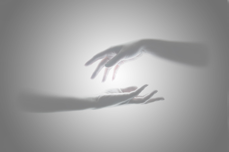 A pair of women's hands in gray with a glow in the middle of the card.