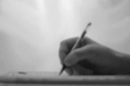 Hand men, the decision of a crossword puzzle, the image is Blurred, light and shadow.の写真素材