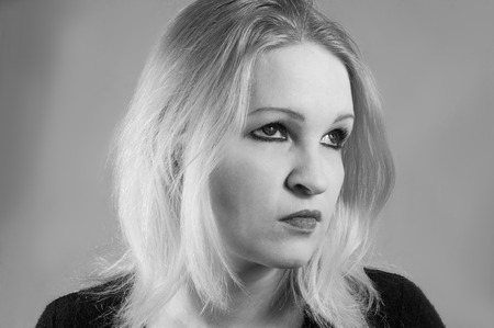 Young woman with blond hair sad and thoughtful expression face, black and white photoの写真素材