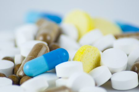 Medicine, capsules and tablets of various shapes and colors on a light background. Close up.の写真素材