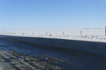 Landscape. Road with melting white snow. Against the blue sky.の写真素材