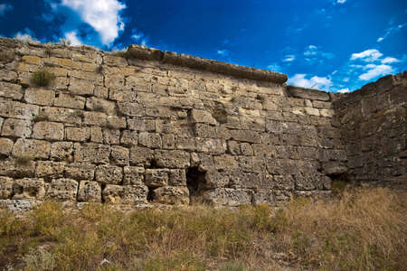 medieval stone wall with grass and skyの写真素材