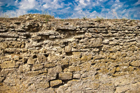 medieval stone wall with grass and skyの写真素材