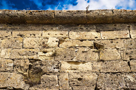 medieval stone wall with grass and skyの写真素材