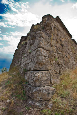 medieval stone wall with grass and skyの写真素材