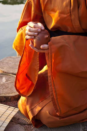 close-up of teapot in hands of a person dressed in kimonoの写真素材