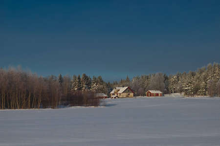 winter landscape with houses in the fieldの写真素材