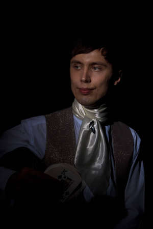 portrait of dandy with card pack, low keyの写真素材