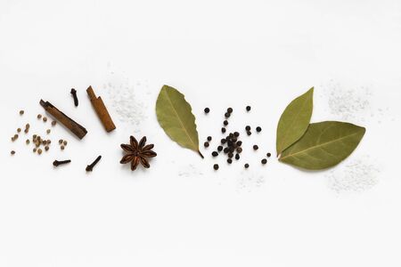 set of assorty colorful spices and herbs in bowls on white background, flat lay, top view