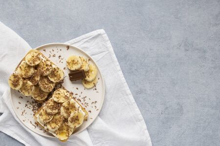 french toast with banana and chocolate on white plate gray background copy space top view flat layの写真素材