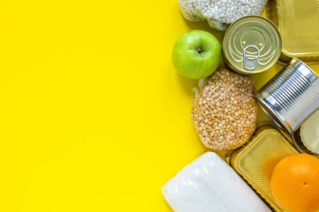 Healthy food on a yellow background. Food delivery in eco bag. Food donations. Flat lay style. Copy space for text.の写真素材