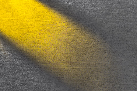 Rough textured concrete background. Color of the year 2021. Wall with light and shadows effect. Illuminating yellow and ultimate gray background.の写真素材