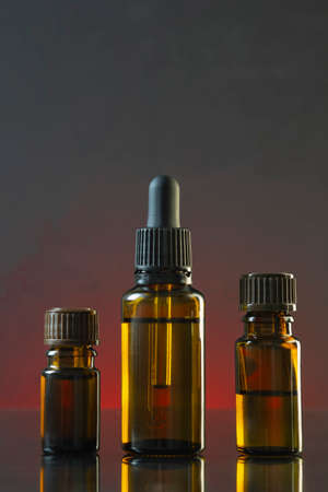 Aromatherapy essential oil dropper bottle on dark background.の写真素材