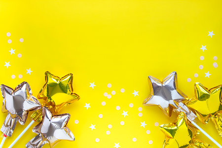 Festive concept party background with star balloon and confetti on yellow. Greeting card copy space.の写真素材