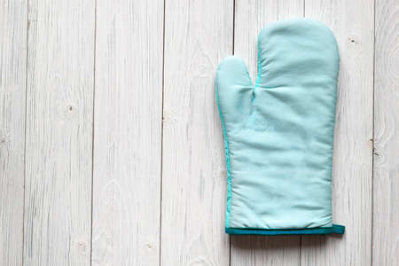 Kitchen turquoise oven mitt mockup design on white old wooden background with copy space for textの写真素材