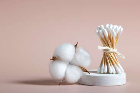 Wooden cotton ear sticks and bud cotton on pastel pink background.の写真素材