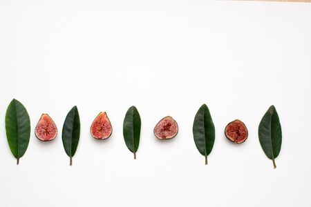 ripe sweet figs on a white background isolate green leaves.の写真素材