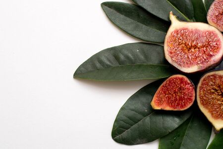 ripe sweet figs on a white background isolate green leaves.の写真素材