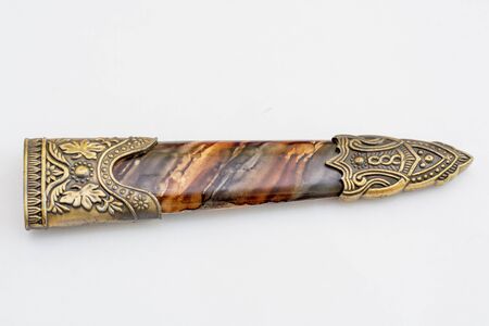 An ornate ceremonial dagger next to a jeweled scabbard is an isolate on a white background