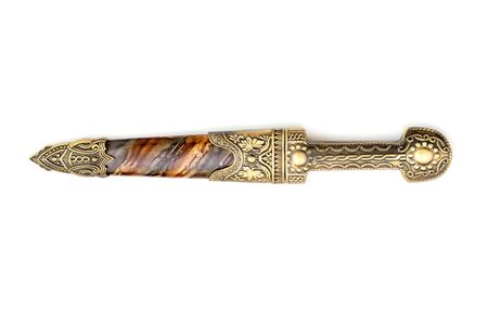 An ornate ceremonial dagger next to a jeweled scabbard is an isolate on a white background
