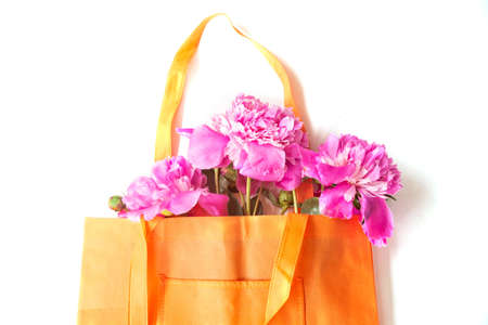 A bunch of peonies in a shopping bag. Top view of a flat layer of copy space. The concept of summer discounts. Seasonal sale.の写真素材