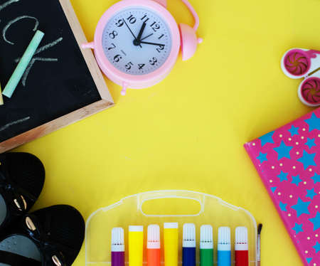 Back to school concept on yellow wooden background. Board for drawing with chalk