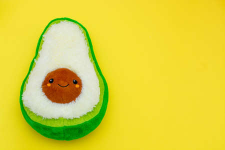 Soft avocado toy on a yellow background. creative modern banner or flyer with copy space. game
