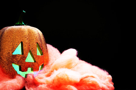 Halloween pumpkin smile and scary eyes for party night. Close up view of scary Halloween pumpkin with eyes glowing inside at black background. Selective focusの写真素材
