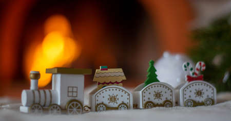 Christmas train, on the background of a Christmas tree and a fireplace. Christmas card.
