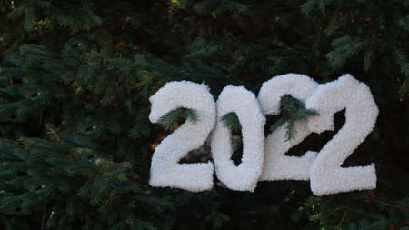 Christmas background with the numbers 2022 on the background of fir branches. New Year and Christmas...