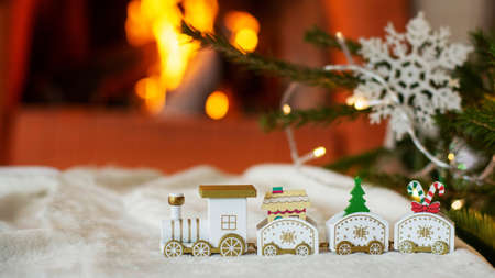 Christmas train, on the background of a Christmas tree and a fireplace. Christmas card.