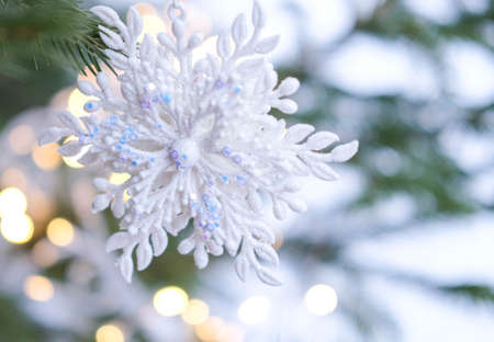 Christmas tree. Christmas tree with a snowflake Christmas toy, with a garland in the background. New Years card.の写真素材