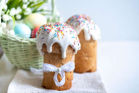Easter cake, with a porcelain rabbit in the background, on a white table. Selective focus. Copy the...