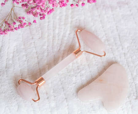 Jade facial roller for cosmetic facial massage with towel. A flat surface on a marble background....