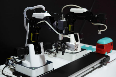 the concept of technology. Mini conveyor. An intelligent factory using modern automated robotic manipulators with parts on a conveyor belt in a production line.の写真素材