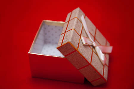 open gift box with ribbon on a red backgroundの写真素材