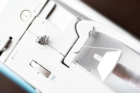 Sewing machine with denim and thread for sewing, close-up. The working process. Part of a sewing...
