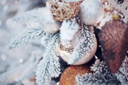 Happy New Year and Merry Christmas. New Year mood, snow-covered branch of spruce with balls and lights.の写真素材