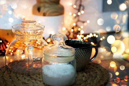 Christmas mood in the kitchen with lights and bokeh. A cup with a jar of sugar on a wicker stand.の写真素材