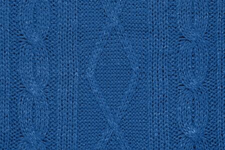 Large woolen background knitted from blue thread. View from above. Element of clothes, style...