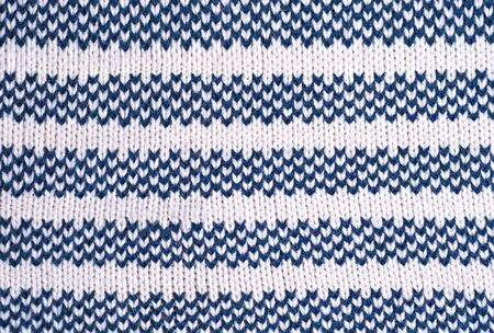Large woolen background knitted from blue thread. View from above. Element of clothes, style...