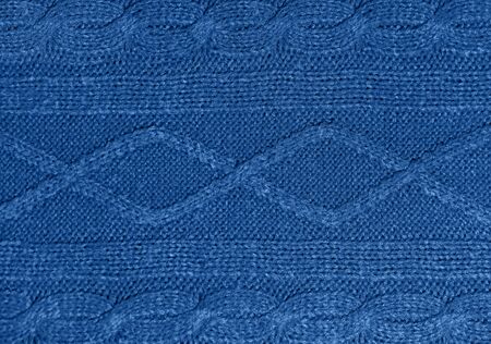 Large woolen background knitted from blue thread. View from above. Element of clothes, style...