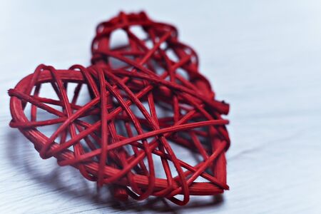 Red wicker heart on a wooden textured background for the holiday. Close-up.の写真素材