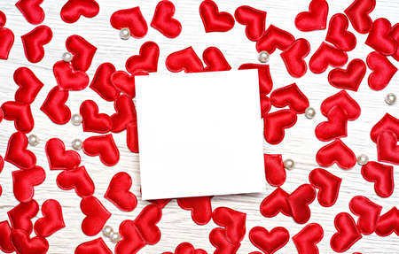 Many small red hearts on a wooden background. With a place for congratulations on a holiday. View from above.の写真素材